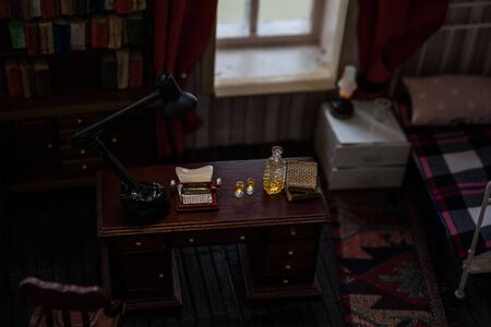A realistic dollhouse living room with furniture and window at night. Man sitting on table in dark...
