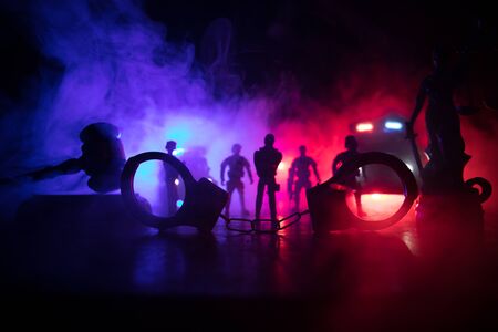 Corona virus concept with police. Stay home for precautionary measures to prevent from corona virus. Anti-riot police give signal to be ready. Smoke on a dark background with lights. Selective focusの写真素材