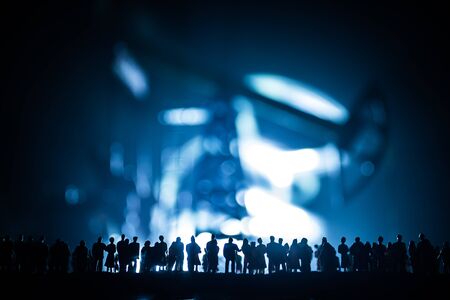 Oil industry crisis concept. Oil stock crisis because Covid global pandemic. Oil pump and oil refining factory at night with fog and backlight. Creative artwork decoration. Selective focus.の写真素材