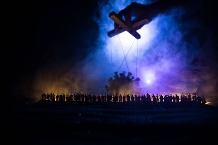 Creative concept of manipulation with coronavirus. Crowd looking on big Corona virus miniature. The...