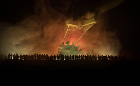 Creative concept of manipulation with coronavirus. Crowd looking on big Corona virus miniature. The...