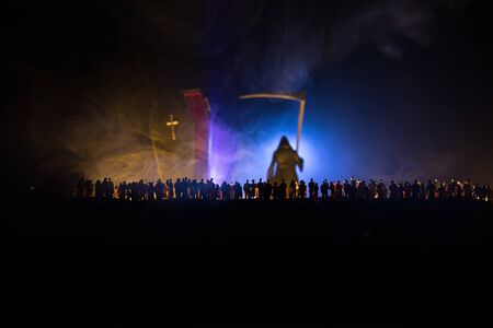 Coronavirus 2019-nCov novel coronavirus concept. Crowd looking on a grim reaper and Corona virus model at night with fog and backlight. Creative artwork decoration. Selective focus.の写真素材