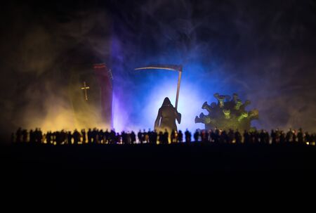 Coronavirus 2019-nCov novel coronavirus concept. Crowd looking on a big coffin and grim reaper at night with fog and backlight. Creative artwork decoration. Selective focus.の写真素材