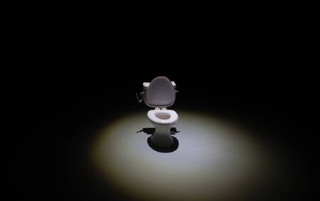 Creative concept. Miniature white toilet bowl on dark foggy background. Selective focusの写真素材