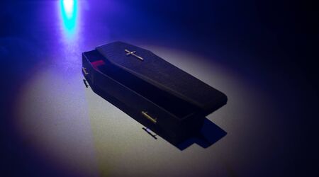 Creative artwork. Miniature wooden coffin on a table with dark background. Selective focus