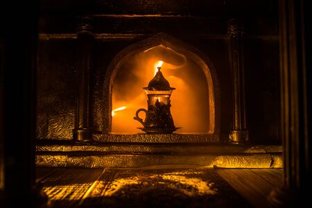 Arabian tea concept. A realistic Arabian interior miniature with window and columns. Arabian tea in glass inside room. Low light lounge interior with carpet. Selective focusの写真素材