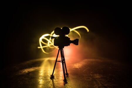 Movie concept. Miniature movie set on dark toned background with fog and empty space. Silhouette of...