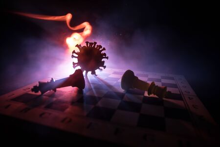 Chess board game concept strategy of business in Covid global pandemic. Big Corona virus miniature model on chessboard with fog and backlight. Creative artwork decoration. Selective focusの写真素材