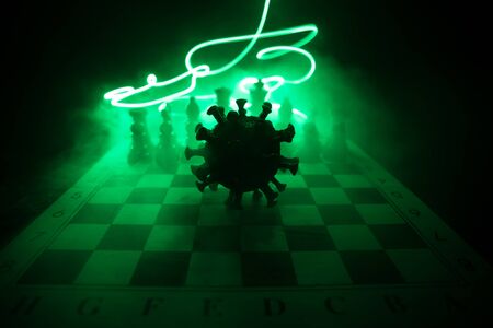 Chess board game concept strategy of business in Covid global pandemic. Big Corona virus miniature model on chessboard with fog and backlight. Creative artwork decoration. Selective focusの写真素材