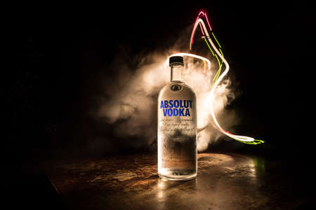 BAKU, AZERBAIJAN - FEB 09, 2020: Absolut Vodka is a brand of vodka, produced near Ahus, in Sweden. Owned by French group Pernod Ricard. Bottle of vodka on wooden table with dark toned foggy background.のeditorial素材