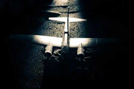 German Junker (Ju-88) night bomber at night. Artwork decoration with scale model of jet-propelled plane in possession. Toned foggy background with light. War scene. Selective focusの写真素材
