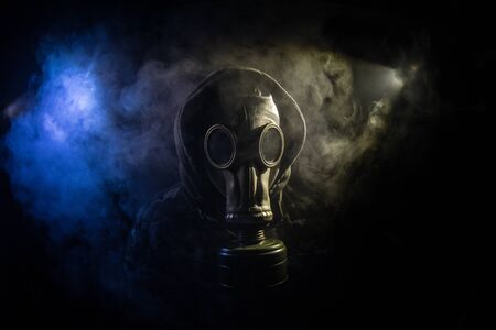 Environmental disaster. Post-apocalyptic survivor in gas mask on a dark background. Dramatic portrait of a man wearing a gas mask. Means for radiation protection. Selective focusの写真素材