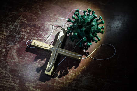 Creative concept of manipulation with coronavirus. Covid19 miniature with strings on a dark...