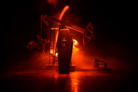 Oil industry crisis concept. Oil stock crisis because Covid global pandemic. Oil pump and oil refining factory at night with fog and backlight. Creative artwork decoration. Selective focus.の写真素材