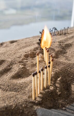 Social distancing concept showing how it can stop spreading of corona virus pandemic. One match with more distance stops burning of others Selective focus. Sunset backgroundの写真素材