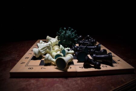 Chess board game concept strategy of business in Covid global pandemic. Big Corona virus miniature...