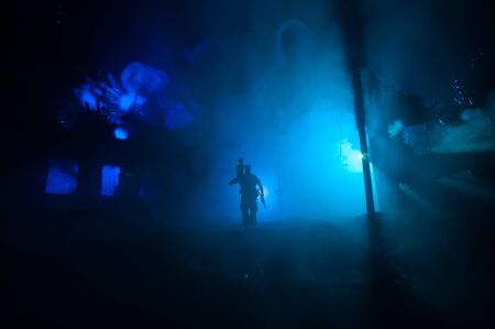 Rescuer carrying little boy in destroyed city. Terrible face of war concept. Creative artwork table decoration with light and fog. Selective focus.の写真素材