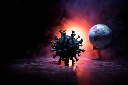 Coronavirus 2019-nCov novel coronavirus concept. Big Corona virus miniature model instead globe with fog and backlight. Creative artwork decoration. Selective focus.の写真素材