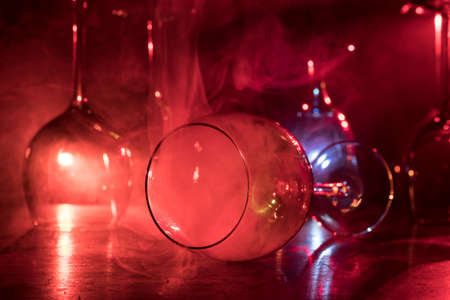 Goblet of wine on wooden table with beautiful toned lights on background. Glasses of wine on dark background. Selective focus. Club drink conceptの写真素材
