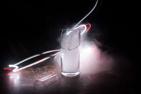 Drink, broken glass concept. Broken glasses on wooden table at dark toned background with fog....