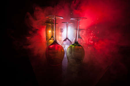 Empty Goblet of wine on wooden table with beautiful toned lights on background. Glasses of wine on...