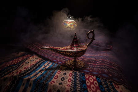 Antique Aladdin arabian nights genie style oil lamp with soft light white smoke, Dark background. Lamp of wishes conceptの写真素材
