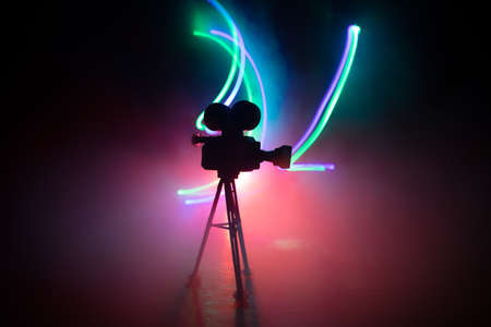 Movie concept. Miniature movie set on dark toned background with fog and empty space. Silhouette of...