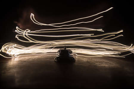 Calling service bell on wooden table with toned lights on dark background. Hotel reception bell,...