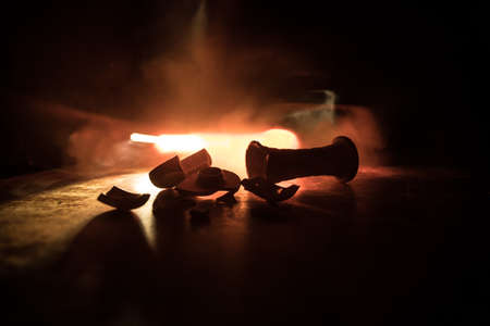 Shisha concept. Broken shisha bowl on wooden table. Dark atmosphere with light. Selective focus.