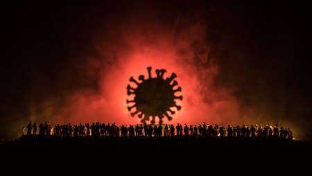 Coronavirus 2019-nCov novel coronavirus concept. Crowd looking on big Corona virus model at night with fog and backlight. Creative artwork decoration. Selective focus.の写真素材