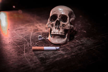No smoking concept. Creative artwork table decoration with cigarettes. Cigarettes cause cancer and kill. still life skull and sigarette. Selective focusの写真素材
