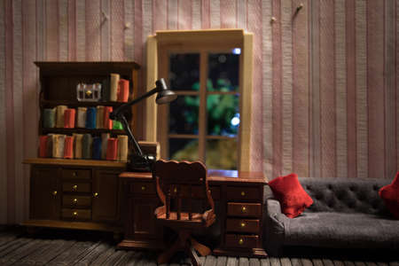 A realistic dollhouse living room with furniture and window at night. Stay home stay safe coronavirus concept. Selective focus.の写真素材
