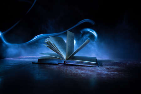 A stack of old books. Vintage book on wooden table. Magic lightning around a glowing book in the...