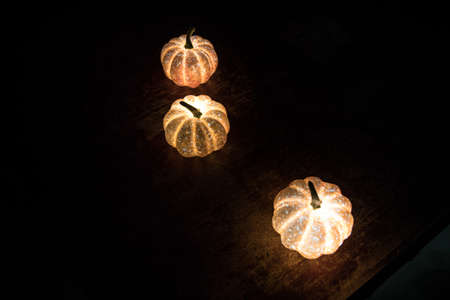 Halloween during Corona virus global pandemic concept. Glowing pumpkins and Covid novel on dark with thematic spooky decorations. Halloween pumpkin on foggy backlight. Selective focusの写真素材