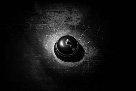 Calling service bell on wooden table with toned lights on dark background. Hotel reception bell,...