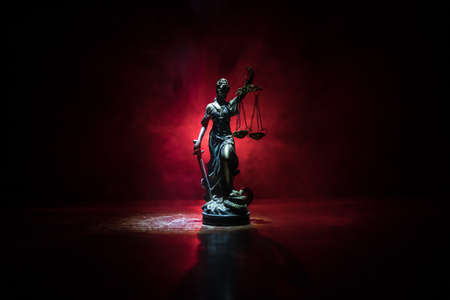 Law concept. Miniature colorful artwork decoration with fog and backlight. The Statue of Justice - lady justice or Iustitia / Justitia the Roman goddess of Justice. Selective focusの写真素材