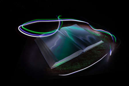A stack of old books. Vintage book on wooden table. Magic lightning around a glowing book in the...