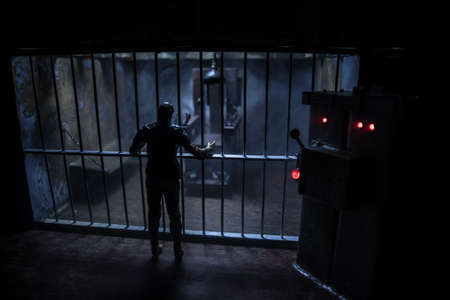 Execution concept. Death penalty electric chair miniature in selective focus inside old prison. Old...
