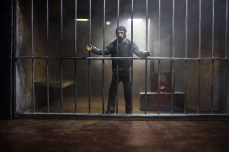 Execution concept. Death penalty guillotine miniature inside old prison. Old prison bars cell lock....