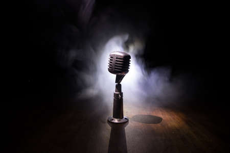 Retro style microphone on background with backlight. Vintage silver Microphone for sound, music, karaoke. Speech broadcast equipment. Live pop, rock musical performance. Selective focusの写真素材