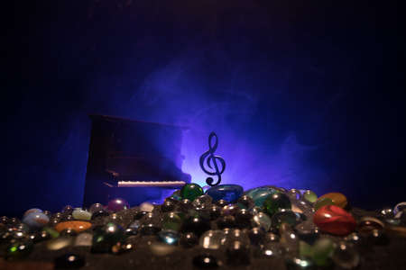 Music concept. Musical symbol treble clef stainless steel miniature with colorful toned light on...