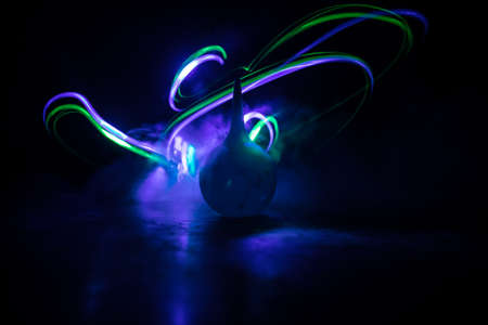 Blue enema on dark background with backlight. Creative artwork decorated with light. Selective focus