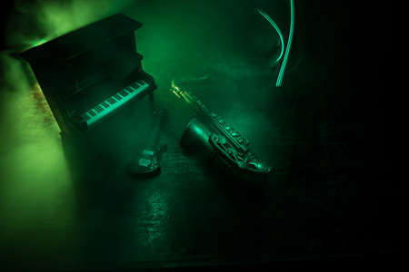 Music concept. Saxophone jazz instrument. Alto gold sax miniature with colorful toned light on foggy background. Musical instruments in lowlight. Selective focusの写真素材