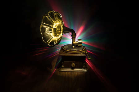 Music concept. Old gramophone on a dark background. Retro gramophone with disc on wooden table with...