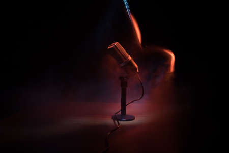 Microphone for sound, music, karaoke in audio studio or stage. Mic technology. Speech broadcast equipment. Microphone in dark room on table with backlight. Selective focusの写真素材