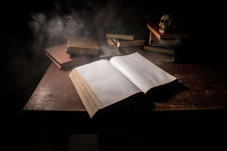 A stack of old books. Vintage book on wooden table. Magic lightning around a glowing book in the...