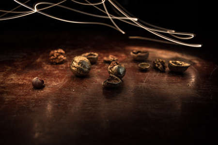 Still life with Walnut kernels and whole walnuts on rustic old wooden table. Creative table...