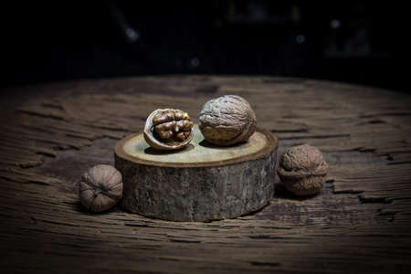 Nut meal concept. Still life with Walnut kernels and whole walnuts on rustic old wooden table....
