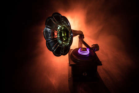 Music concept. Old gramophone on a dark background. Retro gramophone with disc on wooden table with toned backlight. Selective focusの写真素材