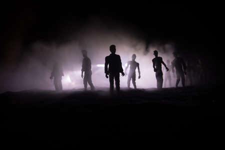 Scary view of zombies at cemetery dead tree, moon, church and spooky cloudy sky with fog, Horror Halloween concept. Selective focusの写真素材
